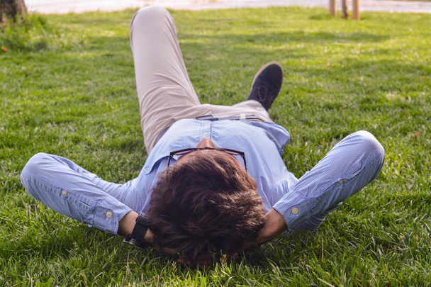 Empresario tumbado en el suelo de hierba
 - Foto, imagen