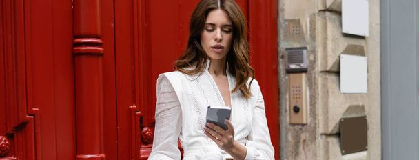 Tyylikäs nainen, joka käyttää kännykkää Pariisin kaupunkikadulla, banneri  - Valokuva, kuva