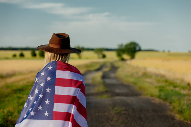 Woman in USA flag and hat on country road - Photo, Image