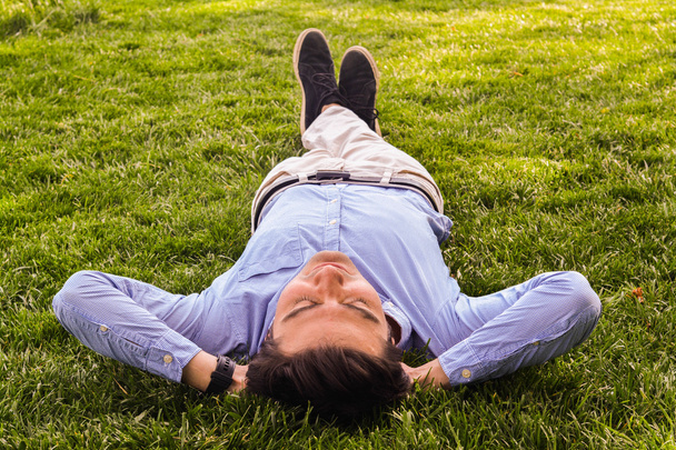 ビジネスマンは草の地面に寝転ぶ - 写真・画像