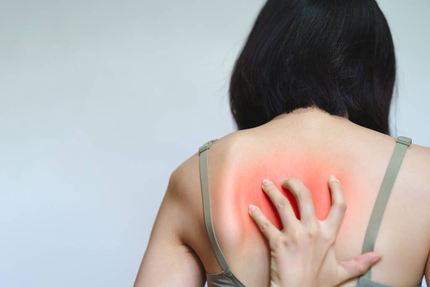 A woman has itching on her back because she is allergic to something. - Foto, Imagen