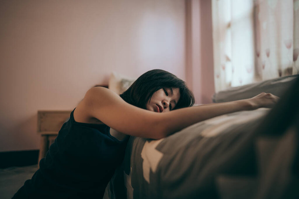 A heartbroken teenage girl sits in the bedroom and regrets it. Depressive symptoms. - Zdjęcie, obraz