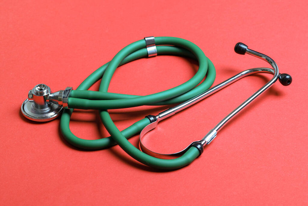Vista dall'alto dello stetoscopio verde su sfondo colorato. Concetto di strumento di diagnosi medica
. - Foto, immagini