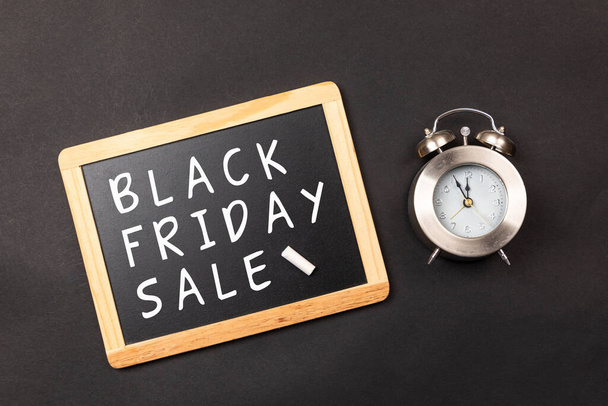 The black Friday sale with clock on a black background - Fotó, kép