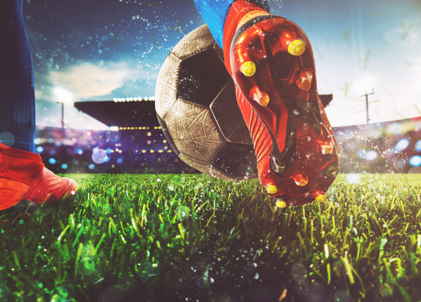 Soccer player kicks the ball vigorously at the stadium - Photo, Image