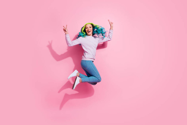 Full length of overjoyed cheerful girl jumping hands fingers demonstrate v-sign isolated on pink color background. - Foto, immagini