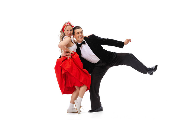 Expressive couple of dancers in vintage retro style outfits dancing social dance isolated on white background. Timeless traditions, 60s ,70s american fashion style. Dancers look excited - Foto, Bild