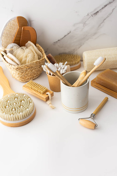 Escovas de dentes de madeira com cerdas naturais em um vidro cerâmico, produtos de cuidados com a pele e rosto, acessórios de banho, spa e conceito de beleza - Foto, Imagem