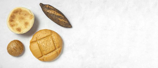 White Background of assorted breads from above. Bakery food. Healthy food concept. flat lay - Zdjęcie, obraz