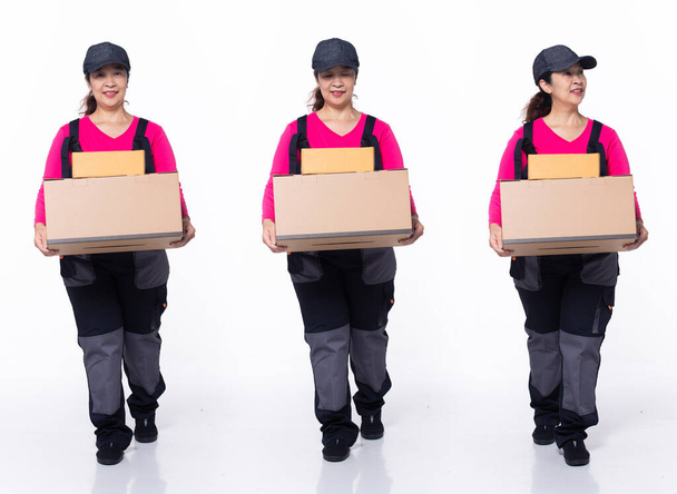 Volledige lengte jaren '40 jaren' 50 Aziatische Senior Woman levering pakket bedrijf, lopen naar voren links rechts, dragen uniform roze jumpsuit. glimlach post vrouwelijke carry box naar ontvanger over witte achtergrond geïsoleerd - Foto, afbeelding