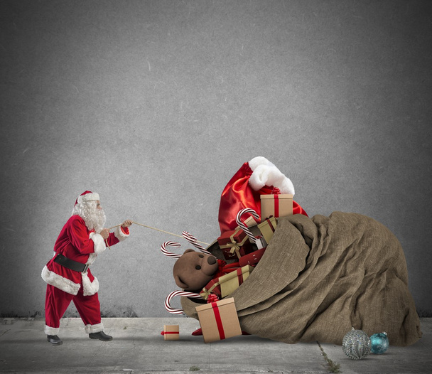 Santa Claus tira de bolsa de regalo
 - Foto, Imagen