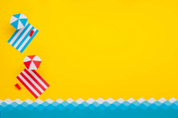 Strandtuch aus Papier, Sonnenschirm am Strand mit Spielzeuggetränk und Sonnenbrille. Sommerurlaub minimalistisches, kreatives Gestaltungskonzept. Papierkunst Hintergrund mit Leerraum für Text. - Foto, Bild