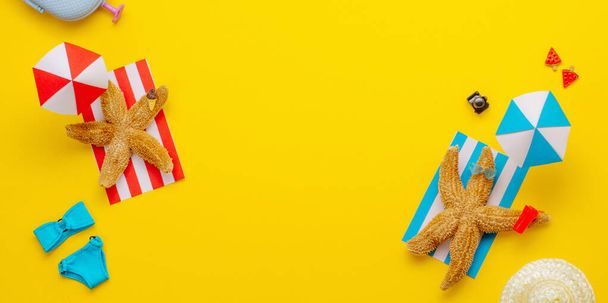 Starfishes descansando en la playa cerca de sombrillas de papel con bebida de juguete y gafas de sol. Concepto vacaciones de verano. Panorama horizontal de pancartas. Papel de fondo de arte con espacio en blanco para texto. - Foto, Imagen
