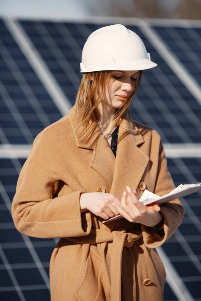Businesswomen working on checking equipment at solar power plant. With tablet checklist, woman working on outdoor at solar power. - Фото, изображение