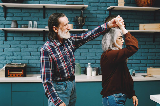 Šťastný starší pár. Starší lidé tančí při vaření v kuchyni. - Fotografie, Obrázek