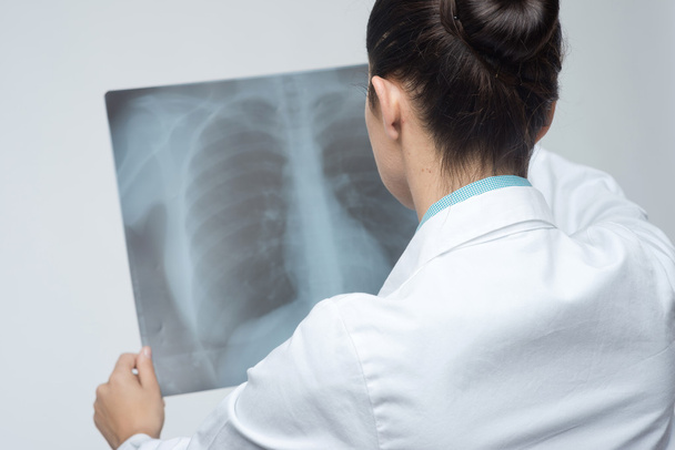 Female doctor examining x-ray - 写真・画像