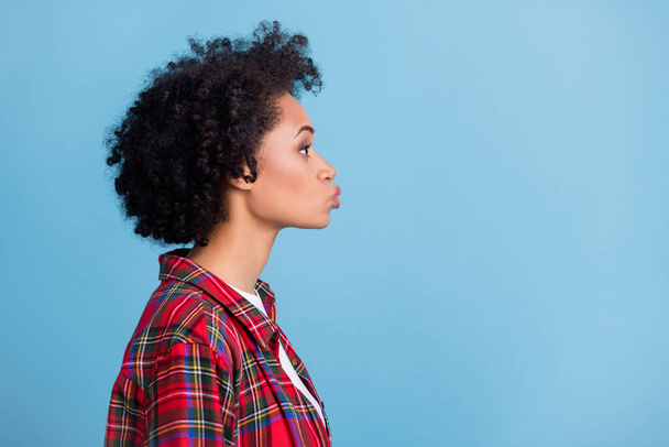 Profile side photo of young afro girl pouted lips send air kiss look empty space isolated over blue color background. - Φωτογραφία, εικόνα