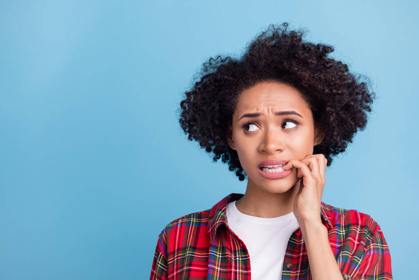 Portrait of attractive scared worried girl biting nail overthinking copy space isolated over blue color background. - Foto, Imagen