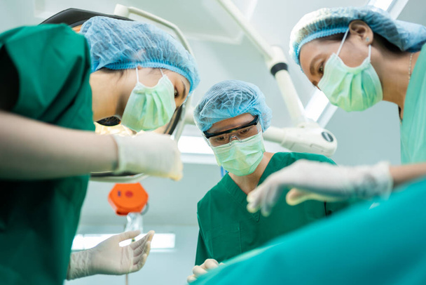 Matala kulma Shot of Professional kirurgit joukkue suorittaa leikkauksen leikkaussalissa, kirurgi, Avustajat, ja sairaanhoitajat Suorittavat leikkauksen potilaan, terveydenhuollon syöpä ja sairauksien hoito käsite - Valokuva, kuva