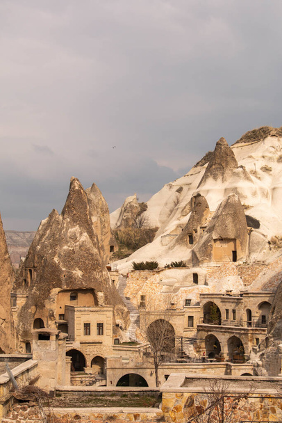 typowe domy na skałach w Kapadocji, Turcja, w pochmurny dzień, w zimie. - Zdjęcie, obraz