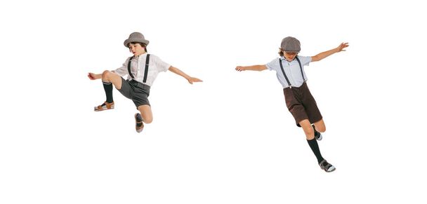 Jumping. Cheerful little boys, stylish kids wearing retro clothes posing isolated over white background. Concept of childhood, vintage summer fashion style. Copy space for ad - Foto, imagen