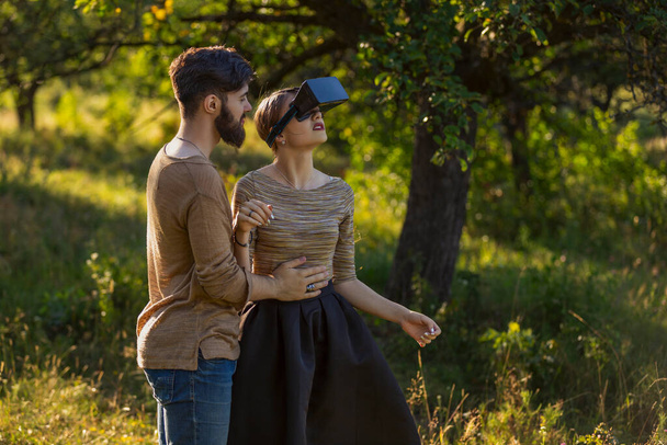 couple in nature, girl in virtual reality glasses close-up - Fotó, kép
