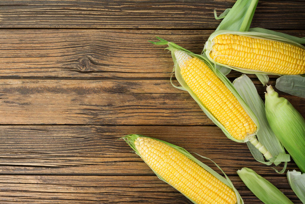 Fresh corn on the cob on a rustic wooden table with copy space - top view - Foto, Imagem