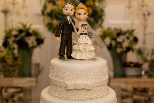 A wedding cake with figurines of bride and groom - Zdjęcie, obraz