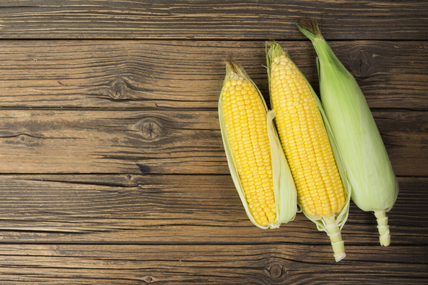 Fresh corn on the cob on a rustic wooden table with copy space - top view - Fotoğraf, Görsel
