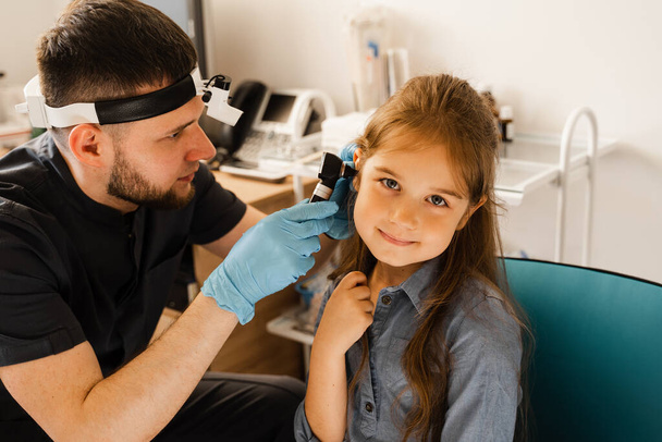耳鼻咽喉科医は小さな女の子の耳を内視鏡で調べる。内視鏡検査。治療子耳痛 - 写真・画像