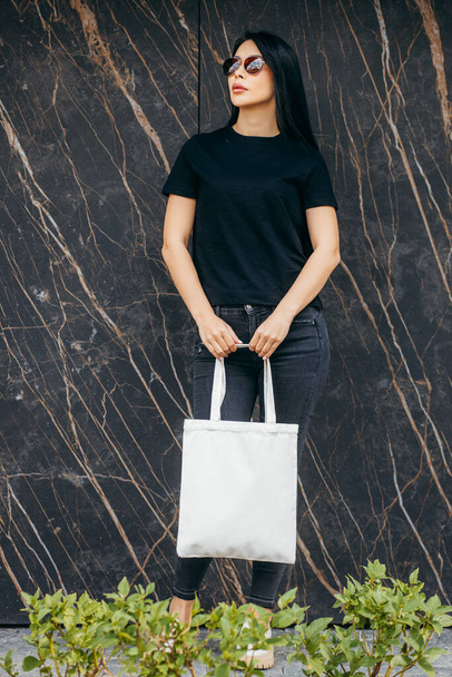 Young asian model  girl on the street holding white eco bag, mock up - Фото, изображение