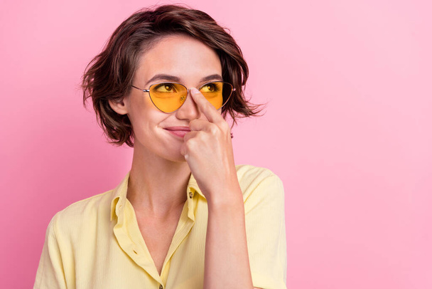 Photo of young girl happy positive smile fix glasses finger look empty space isolated over pink color background. - Valokuva, kuva