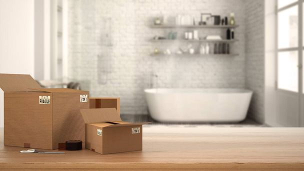 Wooden table, desk or shelf with stack of cardboard boxes over blurred view of vintage bathroom with bathtub, modern interior design, moving house concept with copy space - Photo, Image