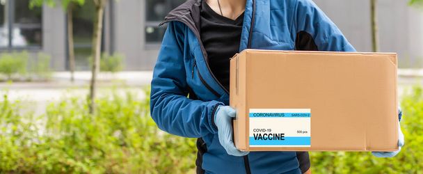 laboratorioavustaja, joka kuljettaa laatikkoa, jossa on rokotteita Covid 19 rokotteelle. - Valokuva, kuva