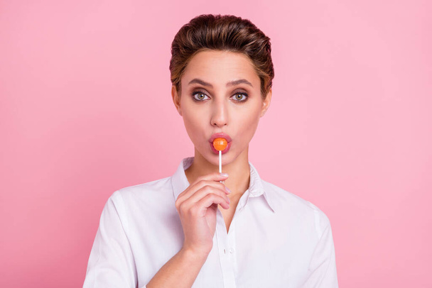 Photo of cool blond millennial lady lick candy wear white shirt isolated on pink color background. - Fotografie, Obrázek