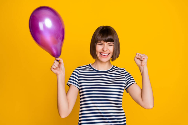 Photo of hooray brunette millennial lady hold balloon yell wear t-shirt isolated on yellow background. - Φωτογραφία, εικόνα