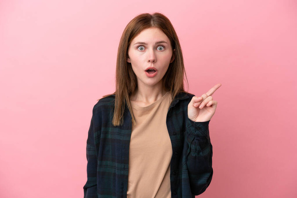 Junge Engländerin isoliert auf rosa Hintergrund in der Absicht, die Lösung zu realisieren, während sie einen Finger hebt - Foto, Bild