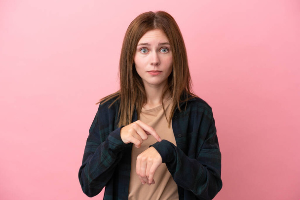 Nuori Englanti nainen eristetty vaaleanpunainen tausta tekee ele myöhässä - Valokuva, kuva