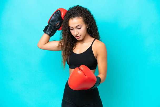 Young Arab woman isolated on blue background with boxing gloves - Photo, Image