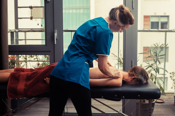 Massage therapist treating patient - Foto, afbeelding