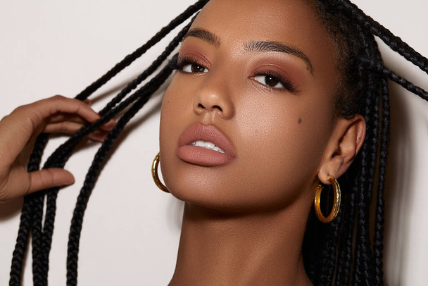 A portrait of an attractive African American female with perfect makeup and African pigtails hair - Foto, Imagen