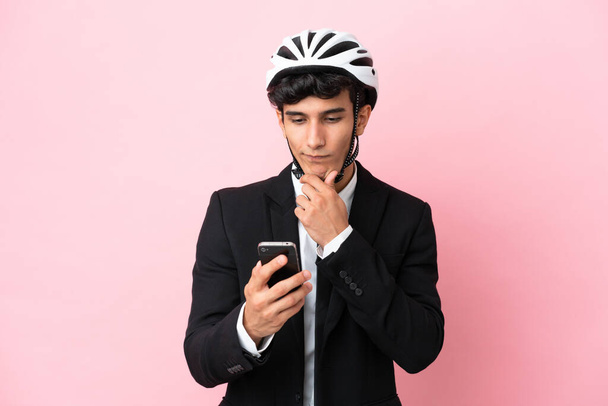 Empresario argentino con casco de bicicleta aislado sobre fondo rosa - Foto, imagen