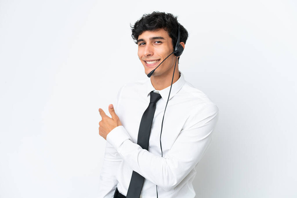 Telemarketer άνθρωπος που εργάζονται με ένα ακουστικό απομονώνονται σε λευκό φόντο δείχνοντας πίσω - Φωτογραφία, εικόνα