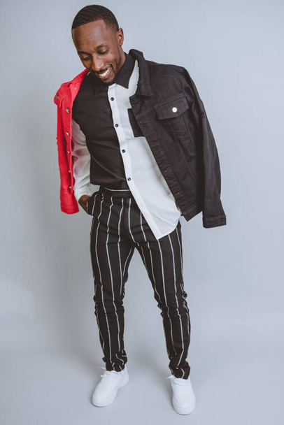 A vertical studio shot of an African American male model posing in fashionable clothes - Foto, Imagen
