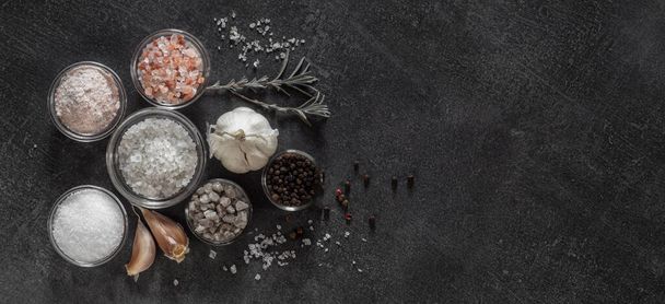 Different types of salt and culinary spices in glass plates on a dark background - Foto, Bild