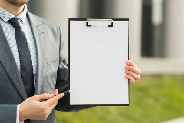 businessman presenting clipboard. High resolution photo - Photo, Image