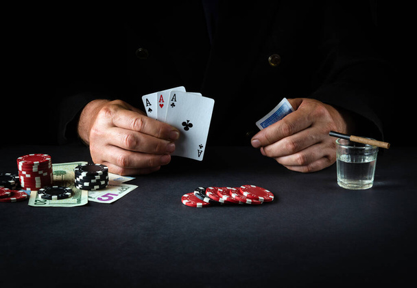 Gry w karty z wygrywającą kombinacją trzech w rodzaju lub zestaw w ręce gracza w klubie pokerowym. Szczęście lub sukces w kasynie - Zdjęcie, obraz