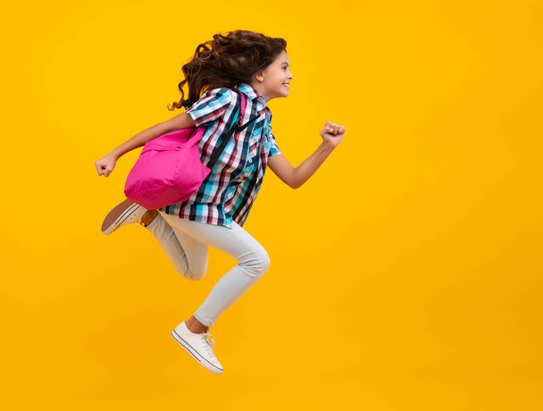 School girl with backpack. Teenager student, isolated background. Learning and knowledge. Go study. Crazy run and jump. Children education concept - Foto, Imagem