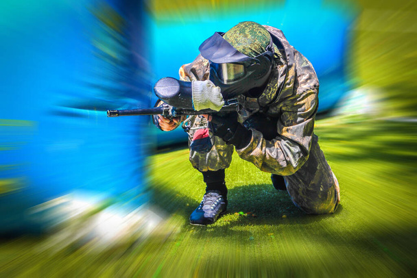 Paintball sportovní hráč v ochranné uniformě a masky hrát s pistolí venku - Fotografie, Obrázek
