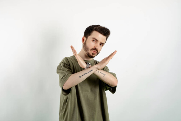 Handsome young man wearing casual clothes posing isolated over white background rejection expression crossing arms and palms doing negative sign, angry face - Foto, immagini